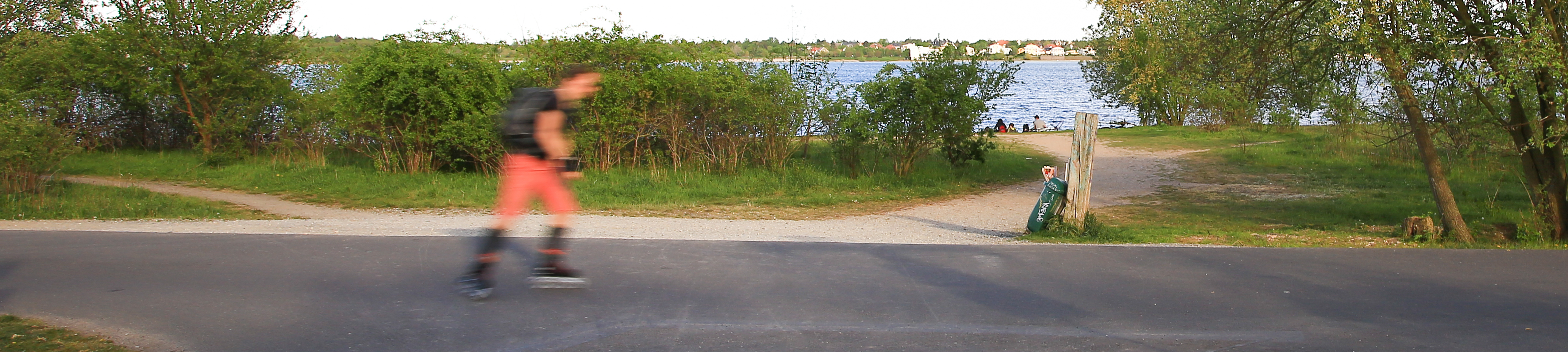 Person skatet über Asphaltweg am See