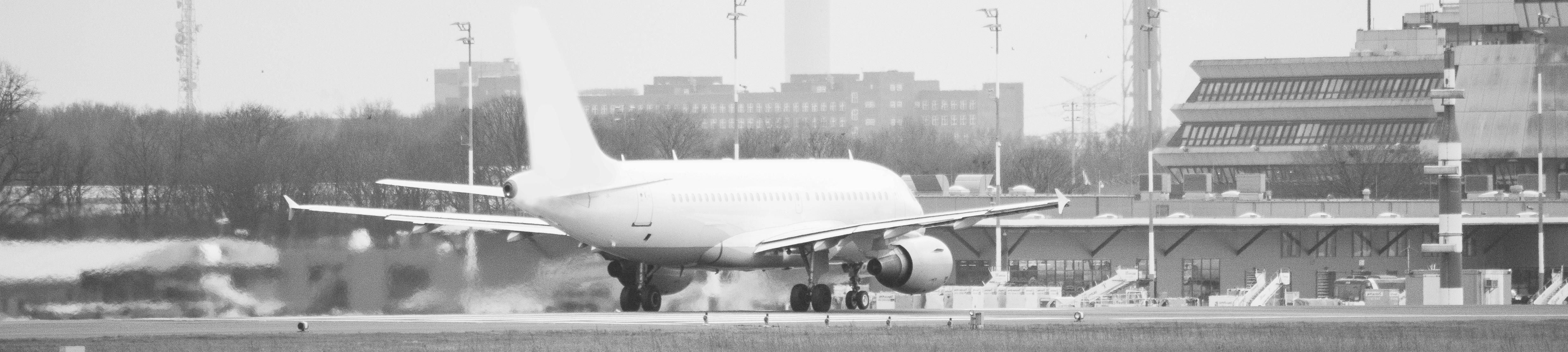 Einpackendes Flugzeug mit Flughafengebäude im Hintergrund